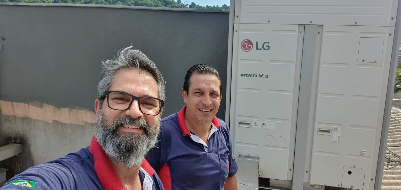 Dois profissionais em visita junto a uma unidade de climatização