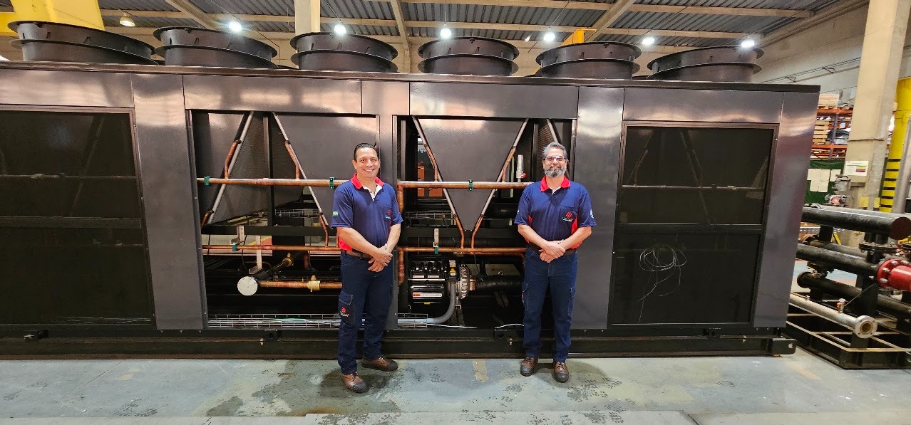 Dois profissionais diante de equipamento de refrigeração industrial